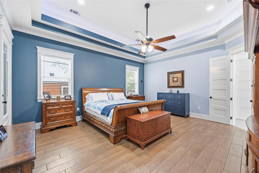 A serene owner’s retreat showcasing tray ceilings, rich designer tones, and an expansive layout crafted for elevated comfort and privacy.