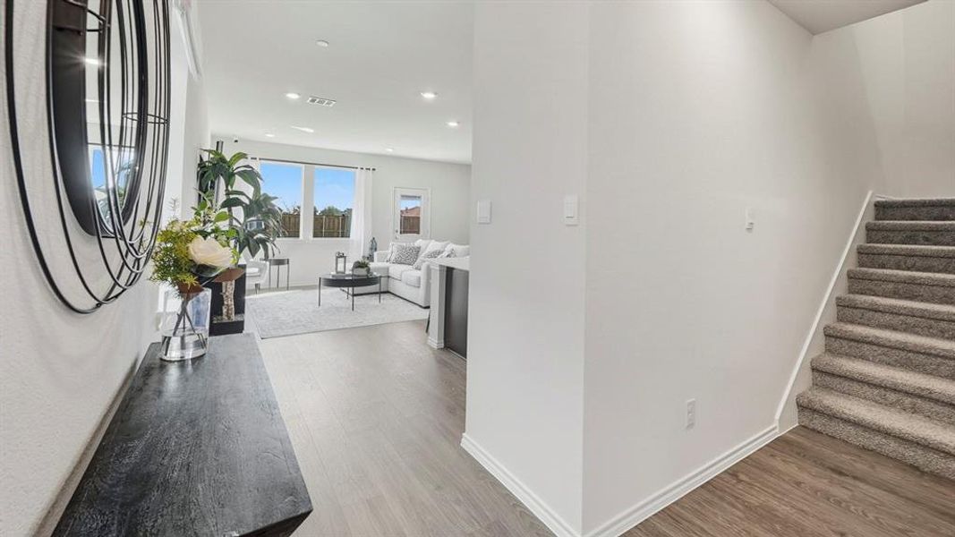 Hallway featuring light wood finished floors, stairs, and recessed lighting Hallway featuring light wood finished floors, stairs, and recessed lighting
