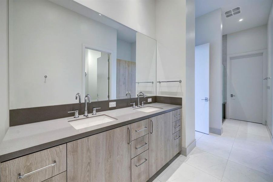 There'll be no fighting for counter or cabinet space in this wide custom vanity featuring two undermount sinks, quartz countertops and gleaming chrome hardware.