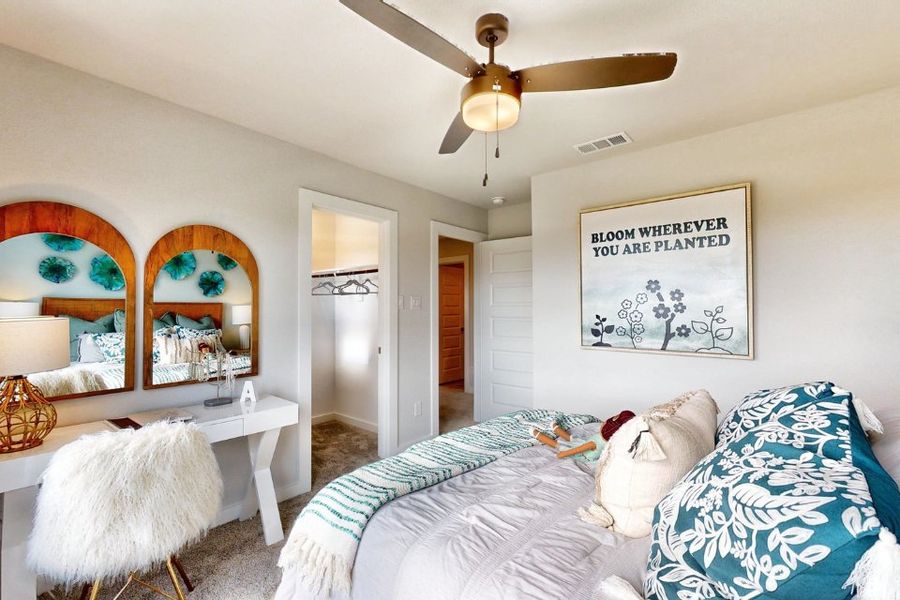 A bedroom with a fan and a bed.