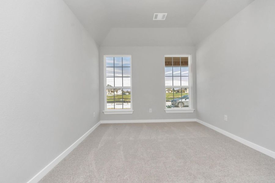 Inviting guest suite adorned with modern charm. The room features elegant 5-panel doors with sleek, contemporary hardware that adds a touch of sophistication. Sink your feet into the plush, fluffy carpet that invites comfort and warmth. Large windows flood the space with an abundance of natural light, framed by privacy blinds that offer the perfect balance between openness and seclusion. Sample photo of completed home with similar floor plan. As-built interior colors and selections may vary.