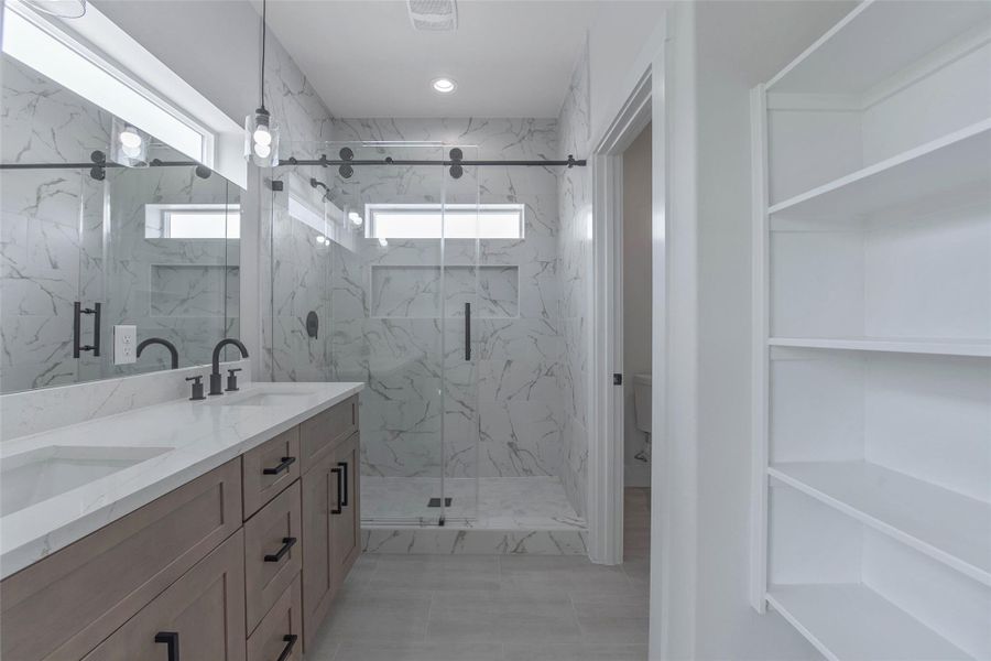 The primary bath offers dual vanities with quartz countertops, a large mirror, a spacious walk-in shower, and ample storage, creating a comfortable and well-appointed retreat. The primary bath offers dual vanities with quartz countertops, a large mirror, a spacious walk-in shower, and ample storage, creating a comfortable and well-appointed retreat.