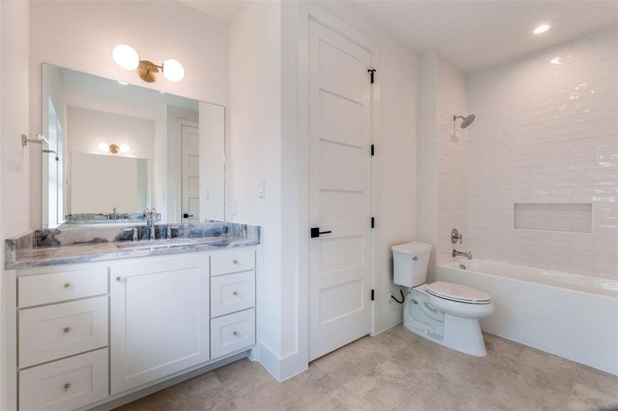 Full bath featuring toilet, shower / bath combination, tile patterned floors, and vanity Full bath featuring toilet, shower / bath combination, tile patterned floors, and vanity