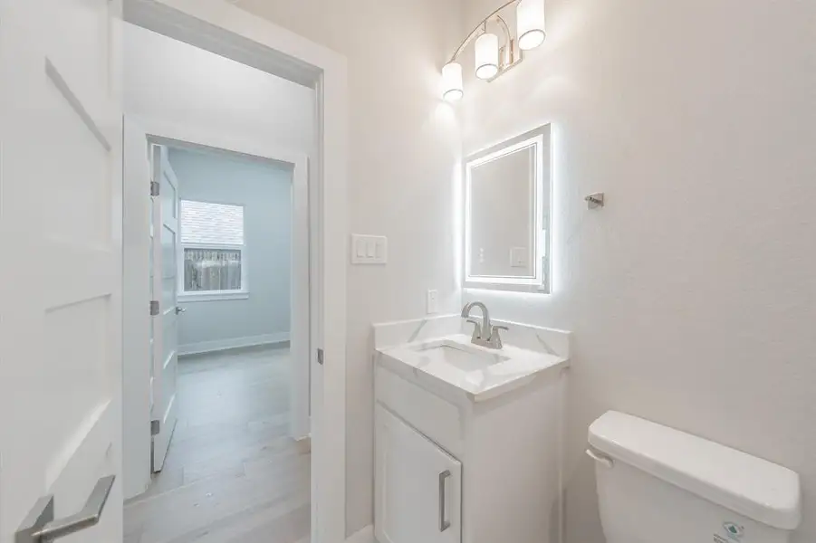 Half bath with vanity and light wood-type flooring