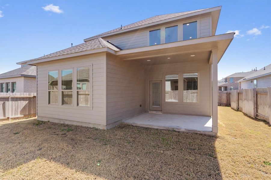 Back of house featuring a patio, a fenced backyard, and roof with shingles