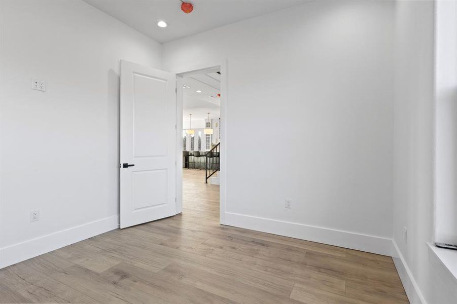 Empty room featuring wood finished floors, baseboards, and recessed lighting Empty room featuring wood finished floors, baseboards, and recessed lighting