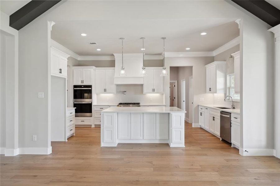 Kitchen featuring white cabinetry, appliances with stainless steel finishes, sink, and a center island