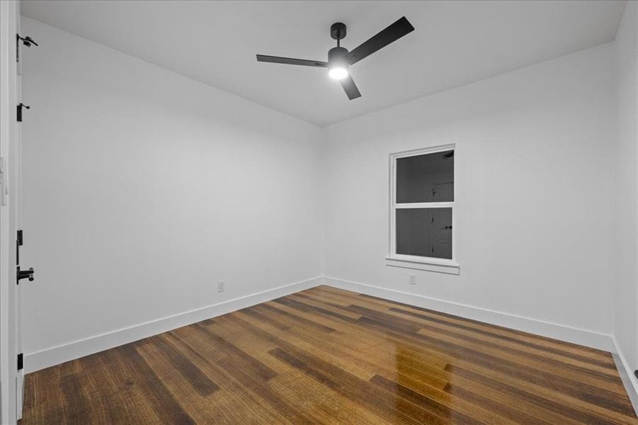 Unfurnished room with wood-style finished floors and a ceiling fan