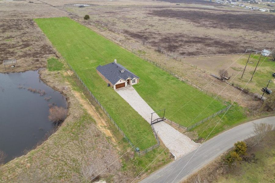 Birds eye view of property with a water view and a rural view