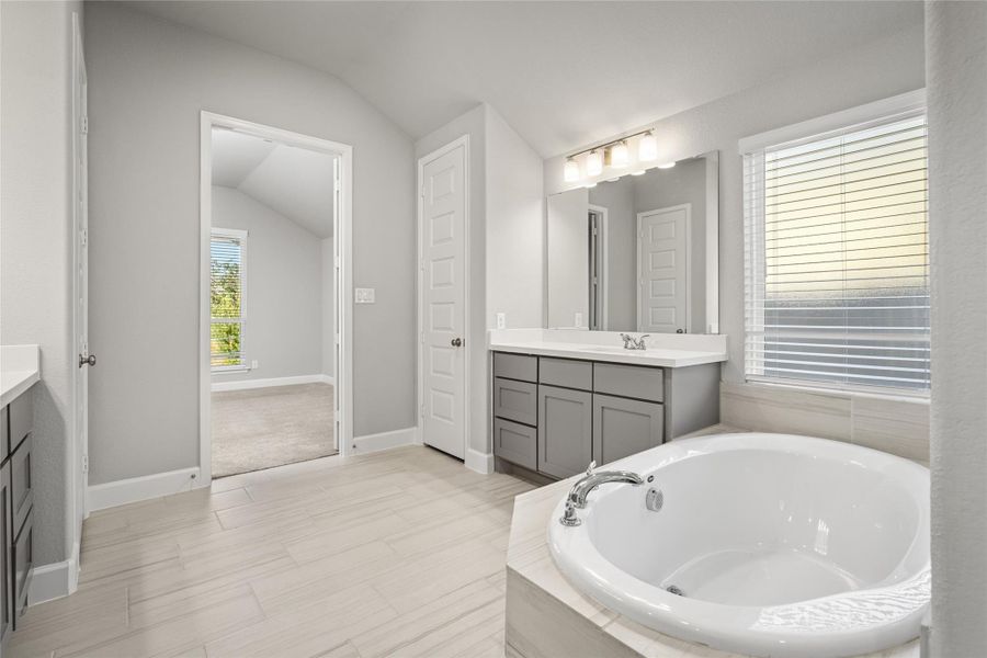 Close-up view of the relaxing Soaking Tub, tiled surround, and second vanity.