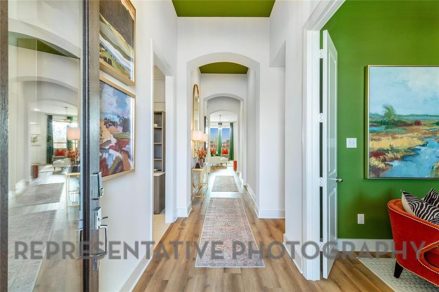 Hallway featuring arched walkways and wood finished floors Hallway featuring arched walkways and wood finished floors
