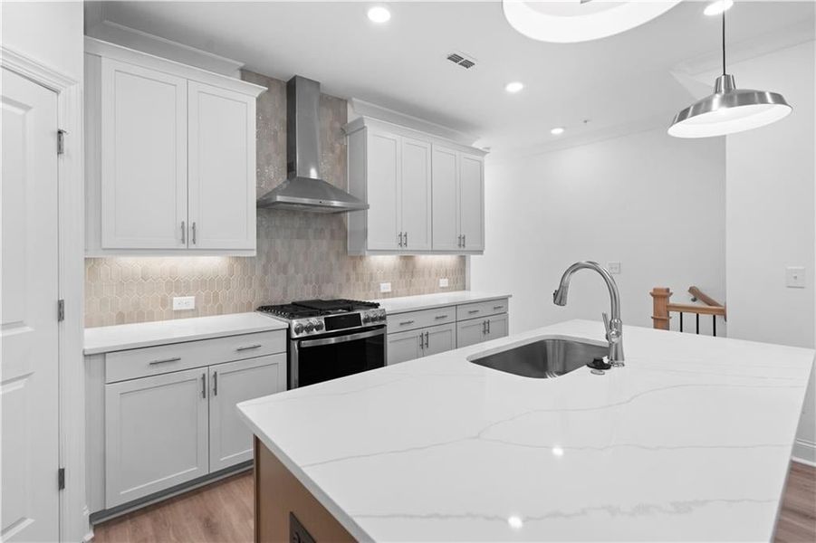 At the heart of the kitchen, a large island with elegant quartz countertops offers generous workspace and casual seating. A deep single-bowl sink is seamlessly integrated for both style and convenience, while overhead pendant lighting adds a touch of sop