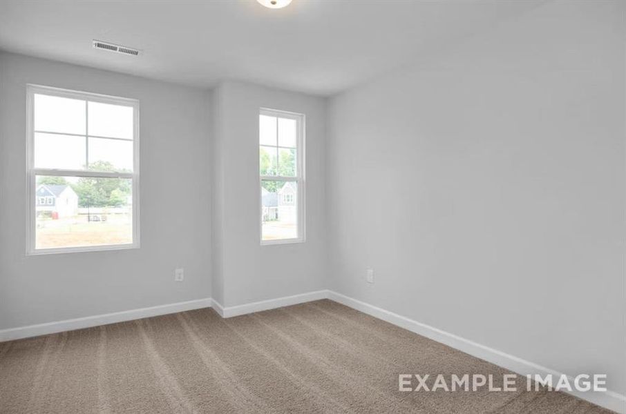 Empty room featuring visible vents, carpet flooring, and baseboards