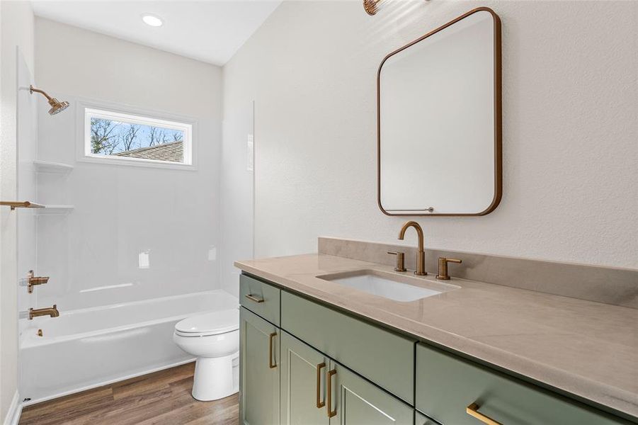 Bathroom with shower / bath combination, vanity, and dark wood finished floors Bathroom with shower / bath combination, vanity, and dark wood finished floors