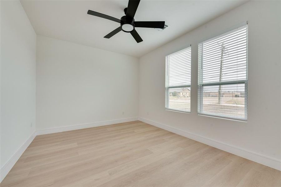 Empty room with ceiling fan and light hardwood / wood-style flooring