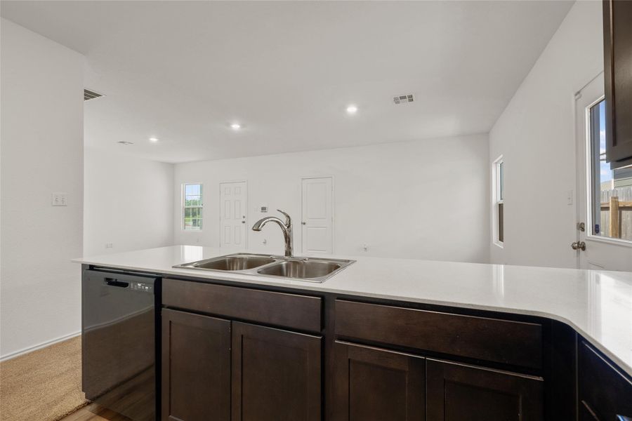 Kitchen featuring dishwasher, dark brown cabinetry, light countertops, and recessed lighting Kitchen featuring dishwasher, dark brown cabinetry, light countertops, and recessed lighting