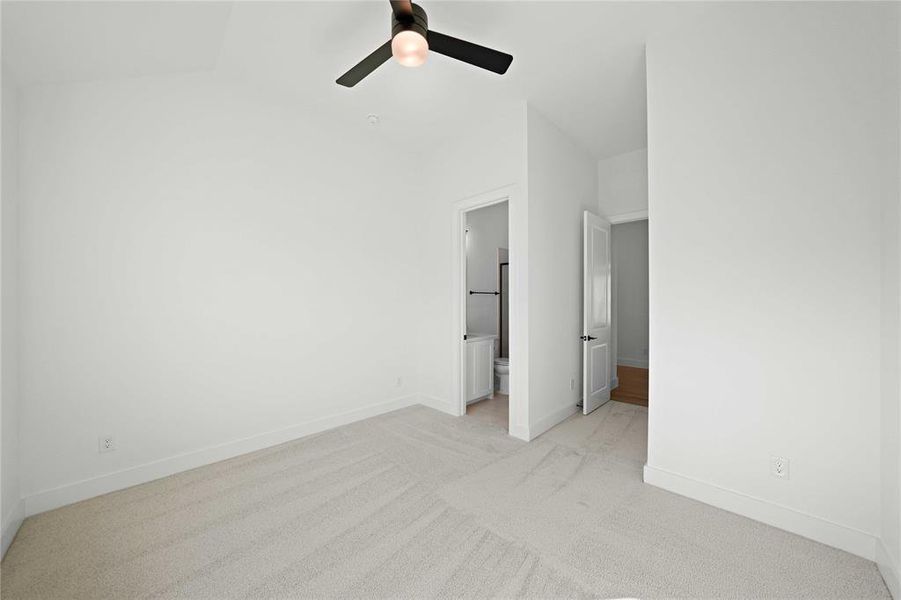 Unfurnished bedroom featuring light carpet, ceiling fan, and ensuite bathroom Unfurnished bedroom featuring light carpet, ceiling fan, and ensuite bathroom