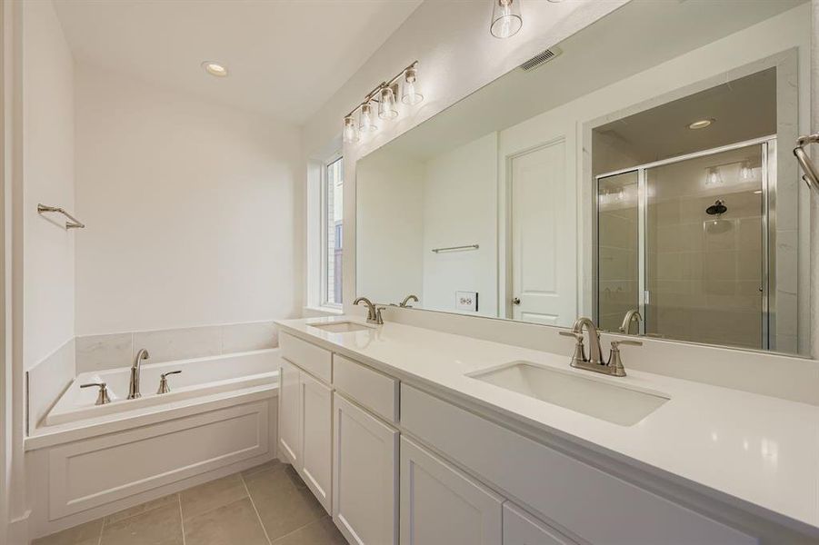 Full bathroom featuring double vanity, a stall shower, light tile patterned flooring, a garden tub, and recessed lighting