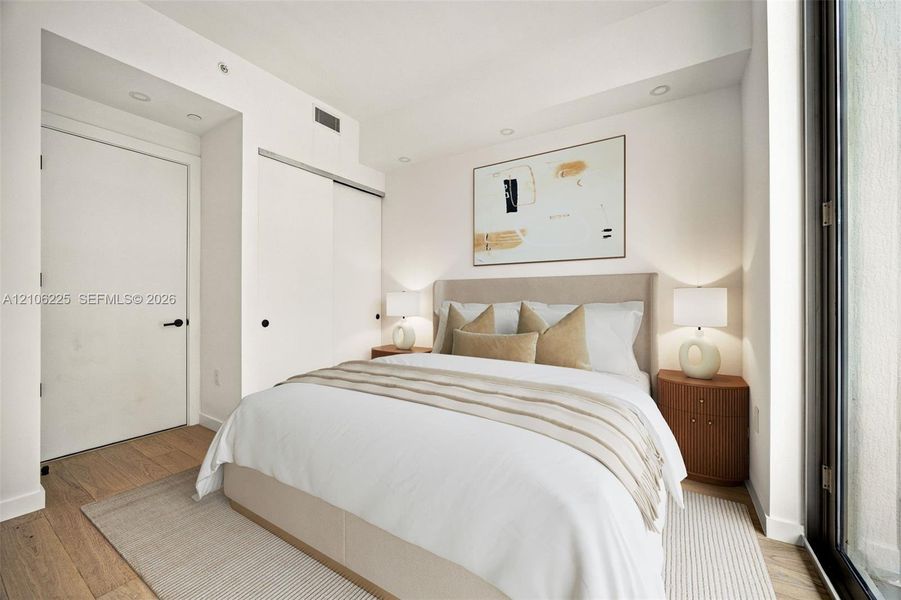 Room featuring wood-finish flooring, recessed lighting, and a sliding-door closet Room featuring wood-finish flooring, recessed lighting, and a sliding-door closet