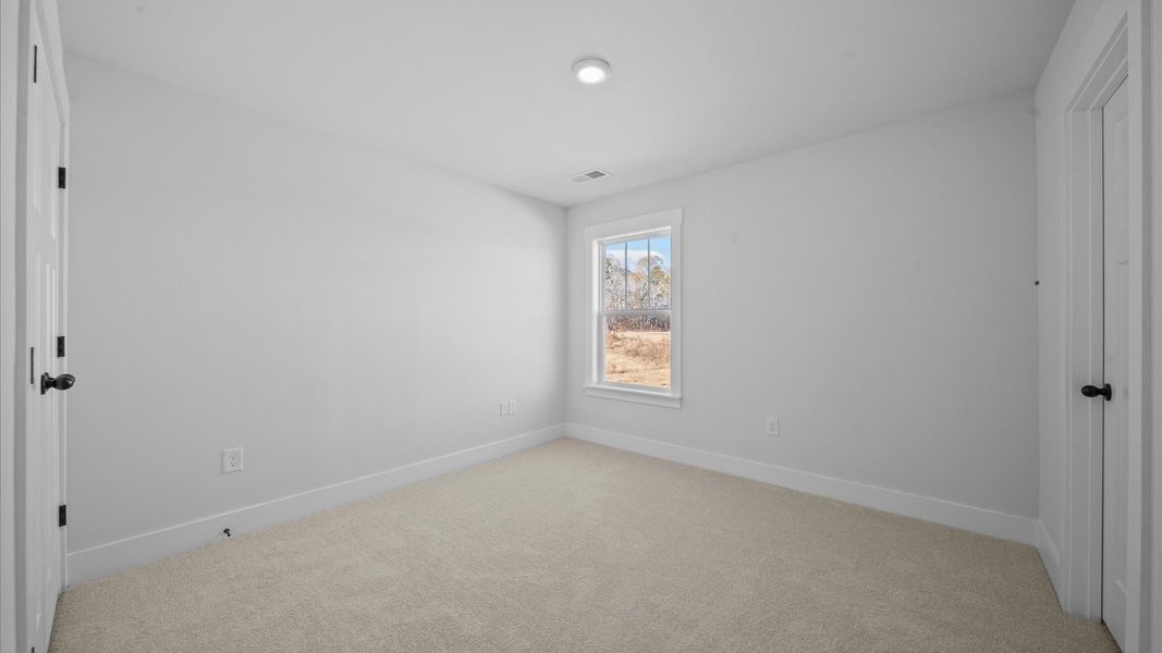 Accomplished design shines in this carpeted bedroom with a functional walk-in closet