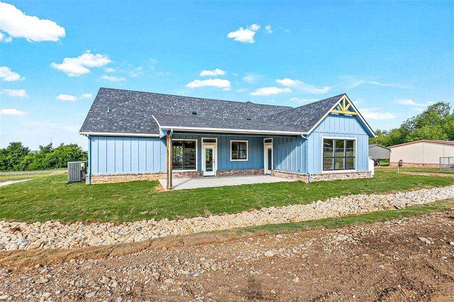 View of front of property with cooling unit and a front yard