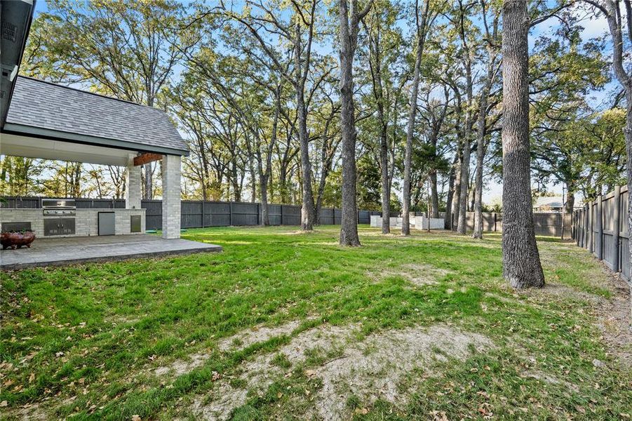 Fenced backyard with area for grilling and a patio area