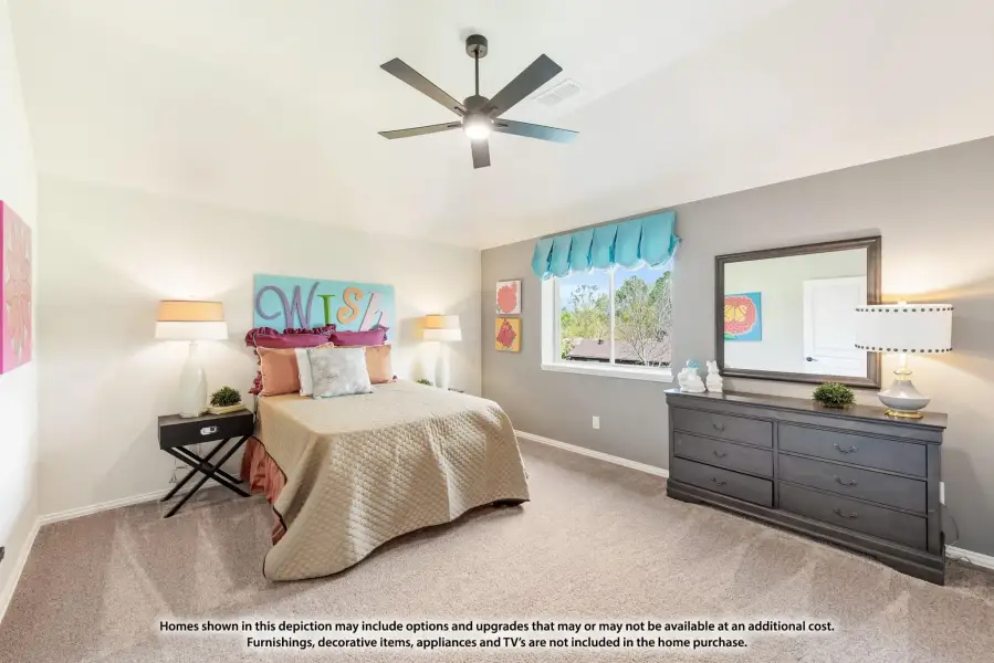 Bedroom with carpet, ceiling fan, dresser with mirror, and colorful wall art above the bed