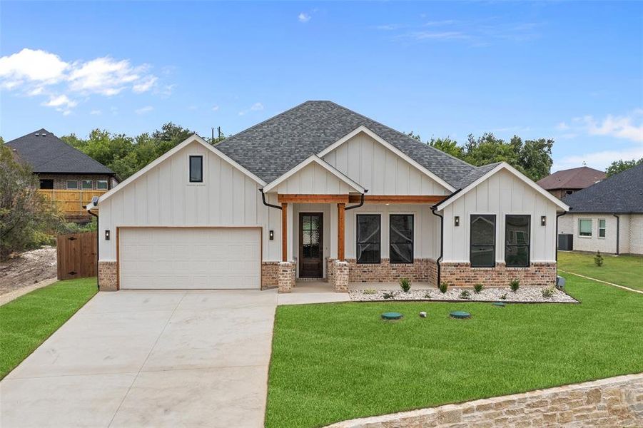 View of front facade with a garage and a front lawn