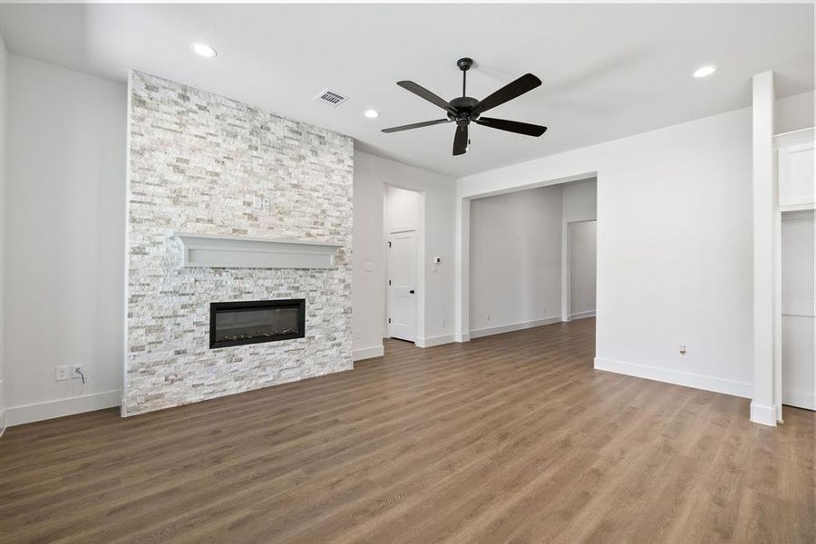 Unfurnished living room featuring a fireplace, dark wood-style floors, recessed lighting, and ceiling fan