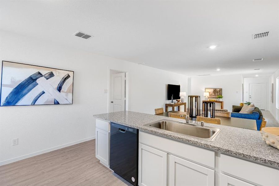 Kitchen with white cabinetry, light wood-type flooring, black dishwasher, open floor plan, and recessed lighting