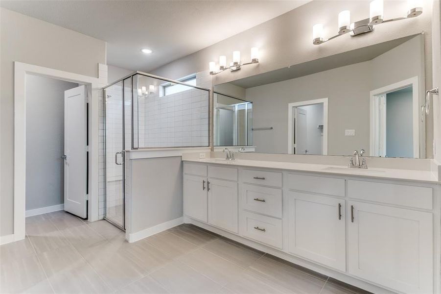 Bathroom with walk in shower, tile patterned flooring, and double sink vanity