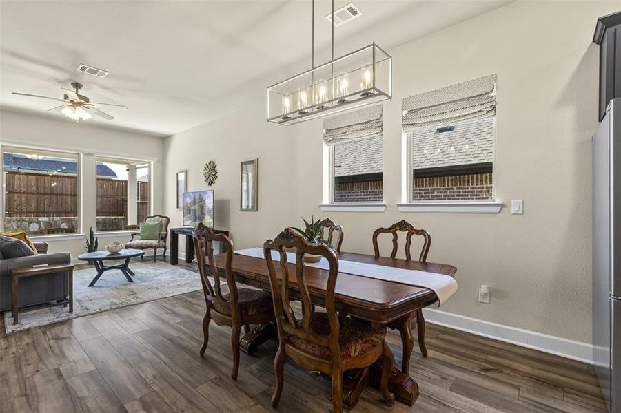 Dining room with dark wood-style flooring and plenty of natural light