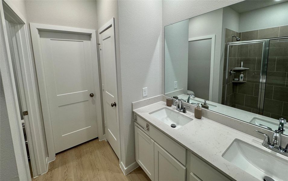 Primary bathroom features double sinks, a spacious walk-in shower, and direct access to a large walk-in closet. Primary bathroom features double sinks, a spacious walk-in shower, and direct access to a large walk-in closet.