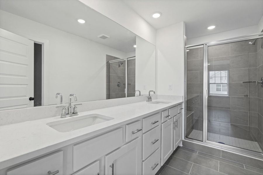 Dual vanity with undermount sinks, stone countertops, and chrome fixtures