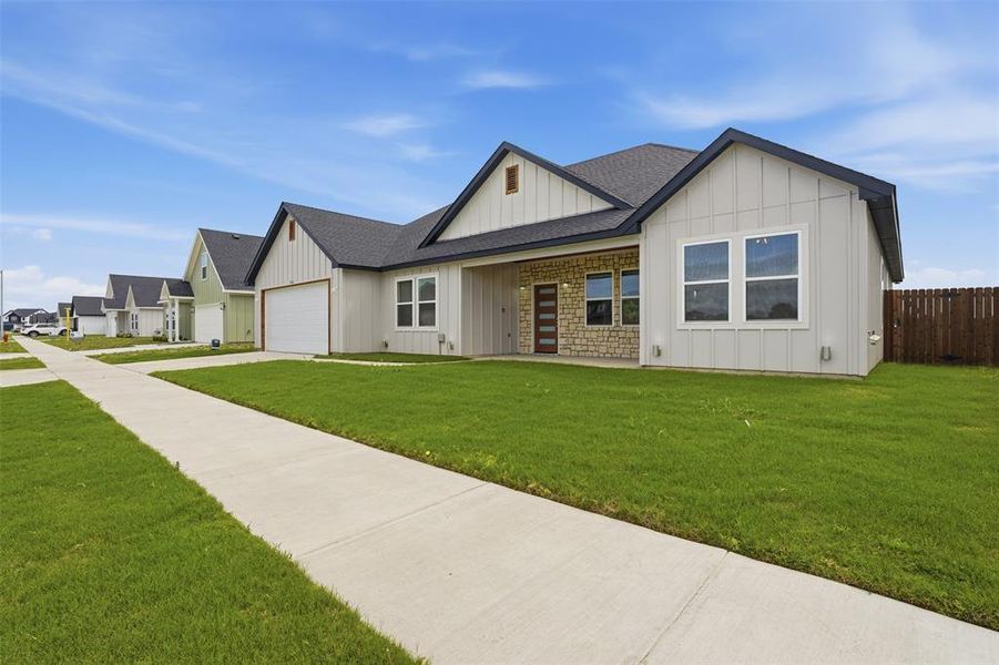 Contemporary single-story home featuring board and batten siding with stone accents