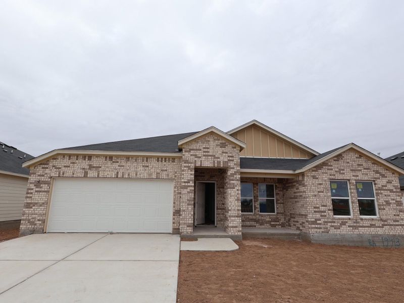 Front exterior of a new home in Carillon, Manor, TX, highlighting curb appeal (Image 1).
