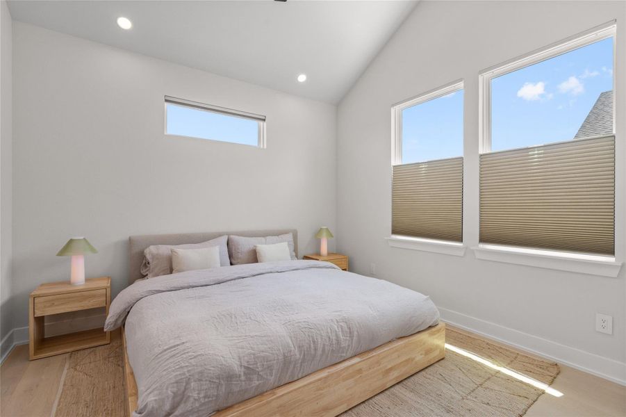 Natural light floods this spacious bedroom, highlighting its vaulted ceiling and sleek hardwood flooring. Natural light floods this spacious bedroom, highlighting its vaulted ceiling and sleek hardwood flooring.