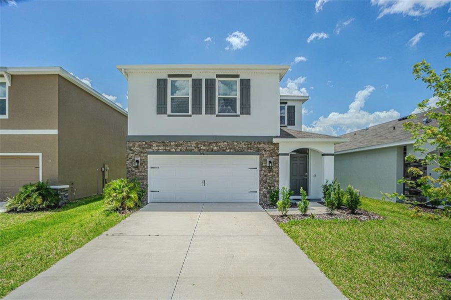 Front exterior of a new home in Deerbrook, Land O' Lakes, FL, highlighting curb appeal (Image 27).