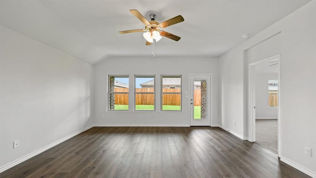Unfurnished room with ceiling fan, dark wood finished floors, and vaulted ceiling