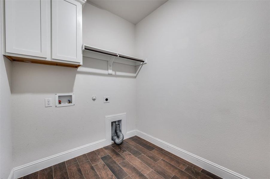 Nice sized laundry room featuring electric dryer hookup, cabinets, dark wood-type flooring, hookup for a gas dryer, and hookup for a washing machine