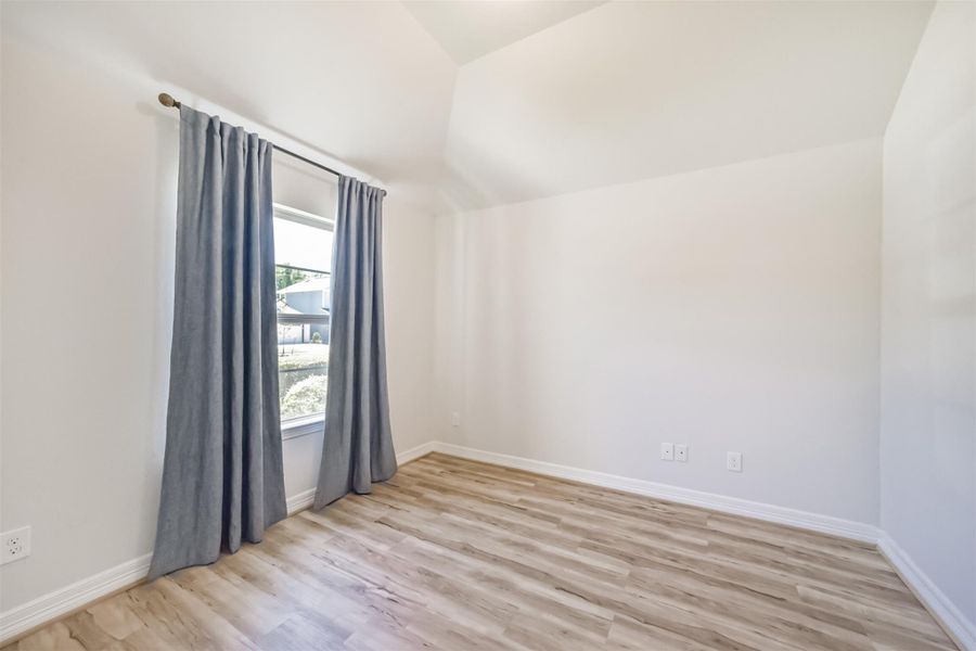 Upon entering the private study, you are greeted by a large window that overlooks the front yard, filling the room with natural light. Blackout drapes offer privacy and light control, while a vaulted ceiling adds a sense of openness to the space. Upon entering the private study, you are greeted by a large window that overlooks the front yard, filling the room with natural light. Blackout drapes offer privacy and light control, while a vaulted ceiling adds a sense of openness to the space.