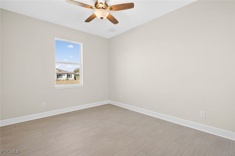 Spare room with wood finish floors and ceiling fan