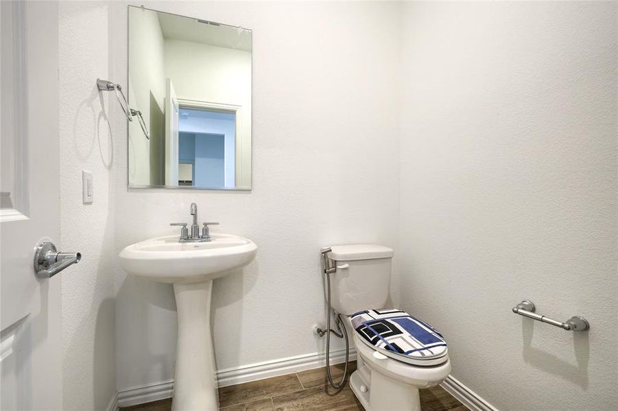 Half bath featuring wood tiled floors and baseboards Half bath featuring wood tiled floors and baseboards