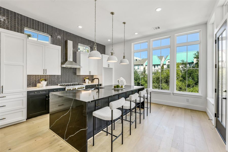 Flooded with natural light, this show stopping kitchen showcases floor-to-ceiling windows, a massive waterfall-edge quartz island, and custom two-tone cabinetry accented by brushed brass hardware. Pendant lighting and professional-grade appliances elevate both style and performance—perfect for the discerning professional who values luxury and practicality. Flooded with natural light, this show stopping kitchen showcases floor-to-ceiling windows, a massive waterfall-edge quartz island, and custom two-tone cabinetry accented by brushed brass hardware. Pendant lighting and professional-grade appliances elevate both style and performance—perfect for the discerning professional who values luxury and practicality.