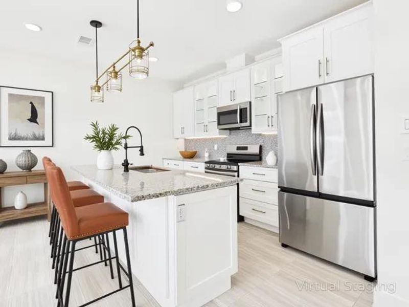 Kitchen featuring stainless steel appliances, light stone countertops, pendant lighting, white cabinets, and recessed lighting Kitchen featuring stainless steel appliances, light stone countertops, pendant lighting, white cabinets, and recessed lighting