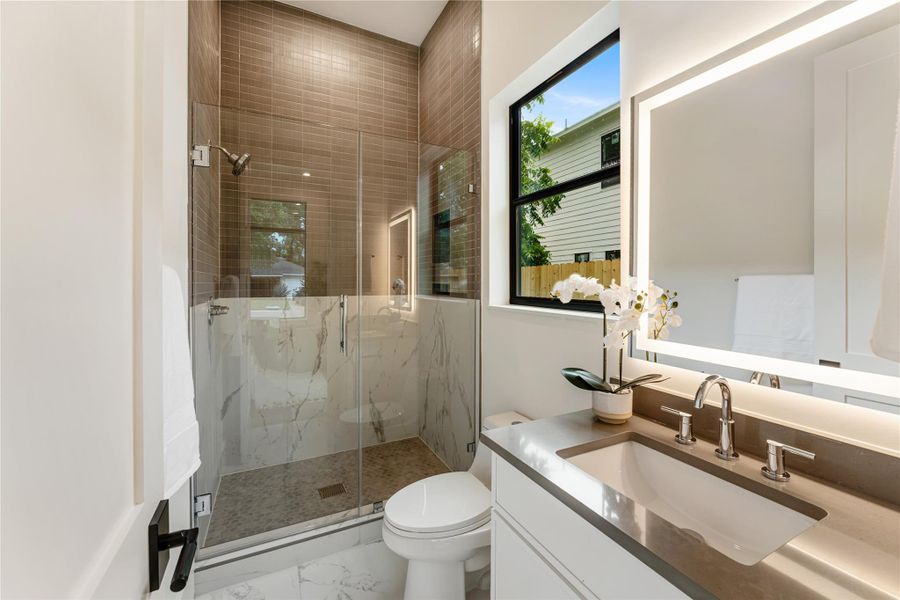 Full bathroom features a spacious walk-in shower with contemporary fixtures and premium tile work.