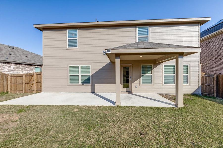 Rear view of house with a yard and a patio