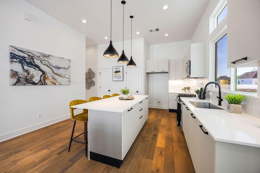 Sleek, modern kitchen with stainless steel appliances, elegant Italian cabinetry, soft closing cabinets/drawers, and a spacious island perfect for entertaining.