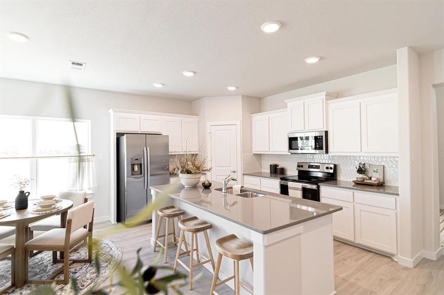 Kitchen with backsplash, stainless steel appliances, white cabinetry, and recessed lighting Kitchen with backsplash, stainless steel appliances, white cabinetry, and recessed lighting