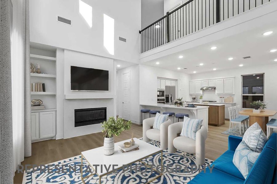 A spacious family room with soaring ceilings and elegant balusters leading to the loft creates an inviting setting for gathering and connection.